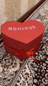 a red heart shaped box with the name mohinur written on it