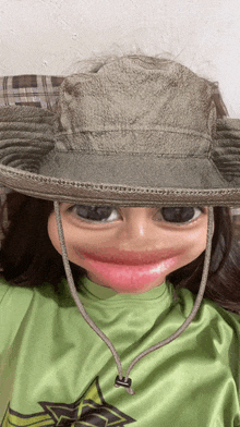 a person wearing a hat and a green shirt with the letter a on it