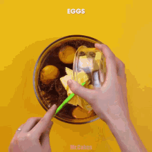 a person is mixing eggs and butter in a glass bowl