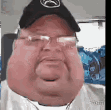a man with glasses and a hat is taking a selfie .