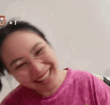 the woman is wearing glasses and a pink shirt and smiling .
