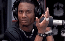 a man wearing headphones and a bracelet is giving the middle finger