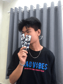 a man wearing a black shirt that says bad vibes on it