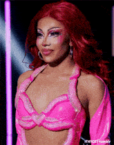 a woman with red hair is wearing a pink top with rhinestones