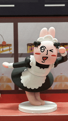 a figurine of a bunny in a maid outfit with a face drawn on it