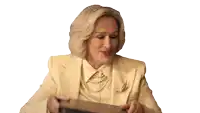 a woman in a yellow suit and pearls is holding a book