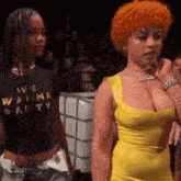 two women are standing next to each other in front of a crowd .