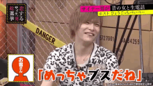 a man is smiling in front of a yellow tape that says danger on it