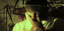 a man wearing a hat covering his mouth with his hand