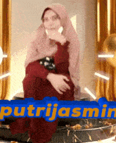 a woman in a hijab is sitting on a pedestal with the name putrijasmin written on it