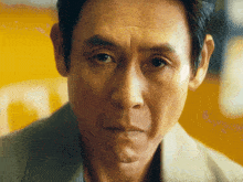 a close up of a man 's face with a yellow background and the letter o visible