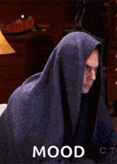 a man is wrapped in a blanket with the word mood written on the bottom