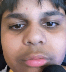 a close up of a person 's face with a microphone in front of it .