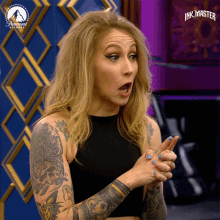 a woman with a tattoo on her arm is on a paramount channel show ink master