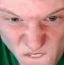 a close up of a man 's face with a green shirt