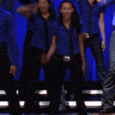 a group of people wearing blue shirts and ties