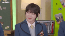 a boy in a school uniform with a badge that says nct wgh