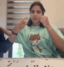 a woman in a green shirt is sitting at a table with a fox on it .