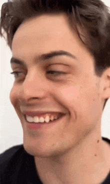 a close up of a man 's face smiling and making a funny face .