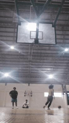 a group of people are playing basketball in an indoor gym