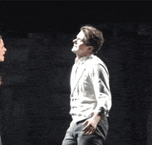 a man in a white shirt is making a funny face on a stage