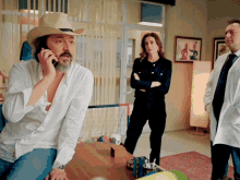 a man in a cowboy hat is talking on a phone