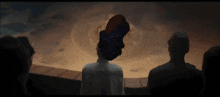 a man in a white shirt is standing in front of a large object in the sky