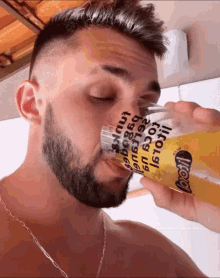 a man is drinking from a glass that says boo