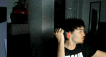 a man wearing a black shirt that says ' puma ' on it is brushing his hair