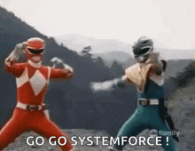 a couple of power rangers are standing next to each other and fighting each other .