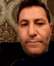 a close up of a man 's face with a patterned background