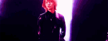 a woman with red hair is standing in front of a blue light with her hands crossed .