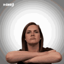a woman with her arms crossed and the swr3 logo in the background
