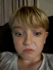 a close up of a young boy 's face with a purple light behind his eyes
