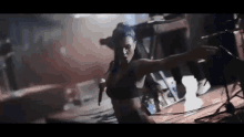 a woman in a bra is dancing on a stage with her arms outstretched .