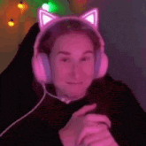 a woman wearing a pair of pink cat ears headphones is sitting in a chair .