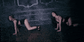 two women are kneeling down and dancing in front of a wall