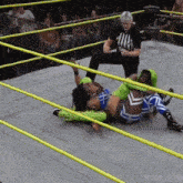 a female wrestler is laying on the floor in a ring with a referee watching