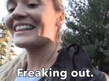 a woman is smiling with the words " freaking out " next to her