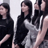 a group of young women are standing next to each other in a row .