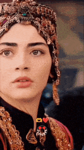 a close up of a woman wearing a turban and a necklace that says i love
