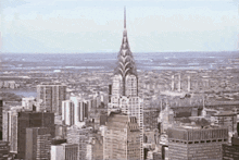 an aerial view of a city with a very tall building in the foreground