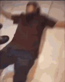 a blurry picture of a man in a brown shirt jumping in the air