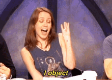 a woman is sitting at a table with her mouth open and says " i object "