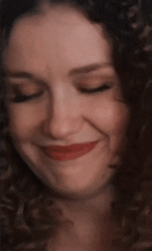 a close up of a woman 's face with her eyes closed and red lips