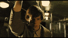a man in a suit and tie is holding onto a railing on a train