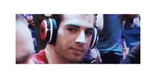 a man wearing headphones is making a funny face in a crowd of people .