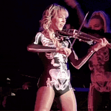 a woman in a skeleton outfit plays a violin