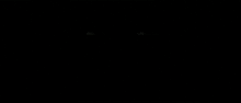 a man is walking through a dark hallway with a light coming out of the ceiling .