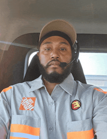 a man wearing a home depot shirt is sitting in the driver 's seat